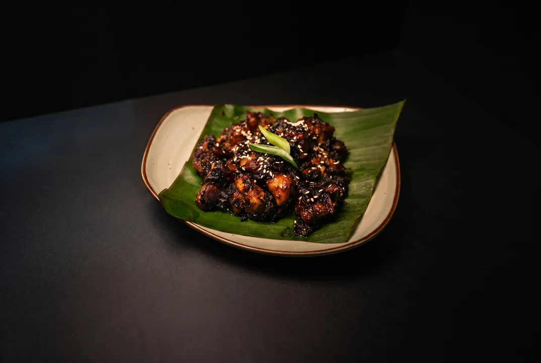 Charred dry-fry glistening with sesame seeds and curry leaves on a banana leaf